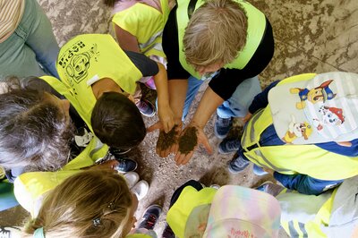In einem Bunker entdecken die Kita-Vorschulkinder zusammen mit Udo Hülsmann vom ASL, dass aus den Gärresten der Biogasanlage noch Dünger wird.