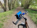 Blick auf einen Radweg in schöner Landschaft über den Lenker hinweg.