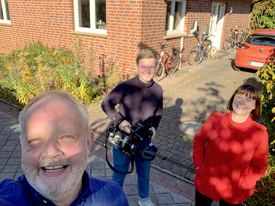 Lächeln im klimafreundlichen Saerbeck: Hilde Gran, Auslandsreporterin des norwegischen Senders TV2, ihr Kameramann Elias und Alfred Riese, der den beiden sein Haus gezeigt hat.